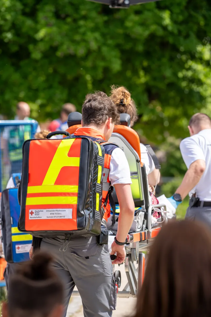 Sanitäter mit Notfallrucksack bringen eine Trage zum Einsatzort
