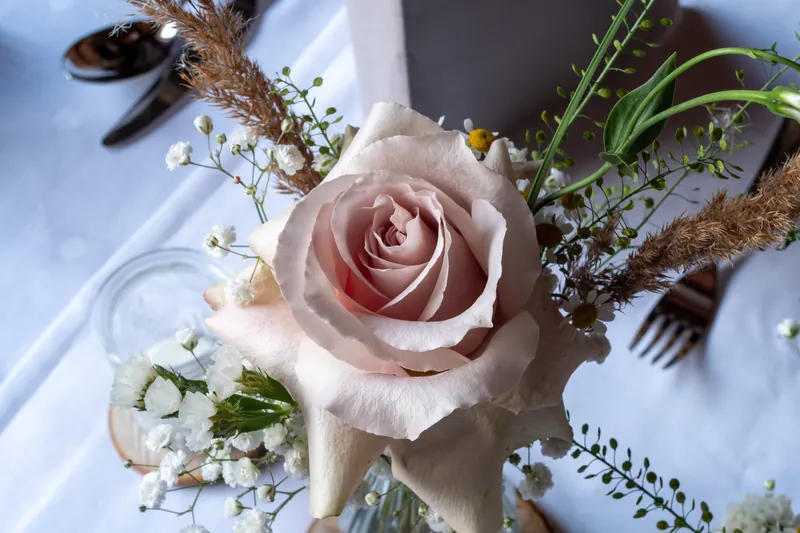 Rose und Trockengräser als Tischdekoration