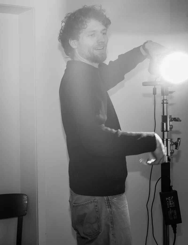 Fotograf stellt ein Studiolicht ein, schwarzweiß