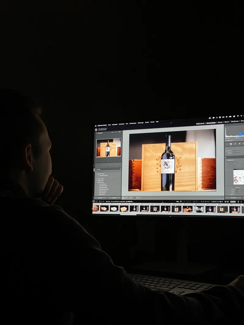 Bildbearbeitung im Dunkeln, eine Weinflasche auf dem Monitor