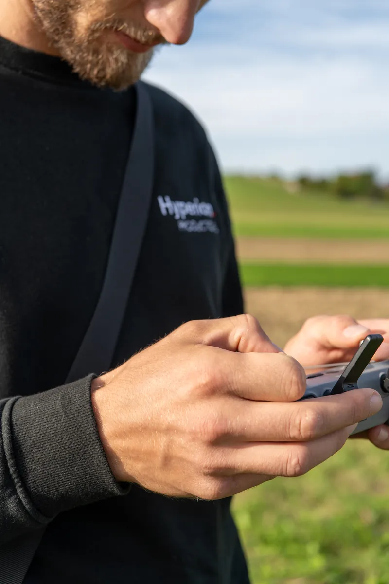 Hände an einer Fernsteuerung, Pullover mit Hyperion-Logo