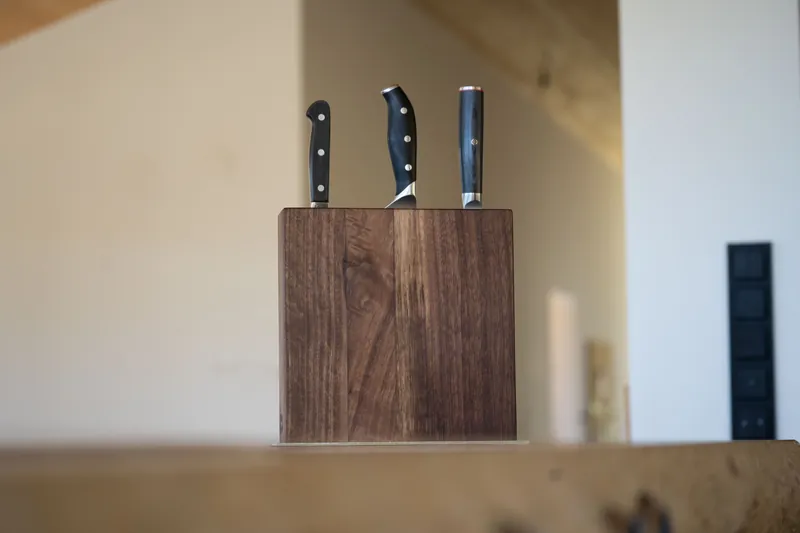 Messerblock aus dunklem Holz mit drei Messern